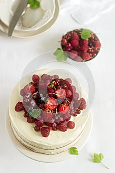 Summer home biscuit cake with curd cream, decorated with fresh berries of strawberries, raspberries and currants.