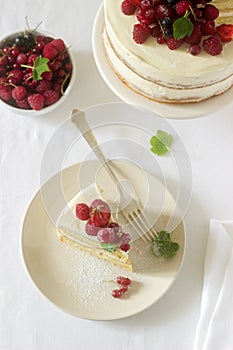 Summer home biscuit cake with curd cream, decorated with fresh berries of strawberries, raspberries and currants.