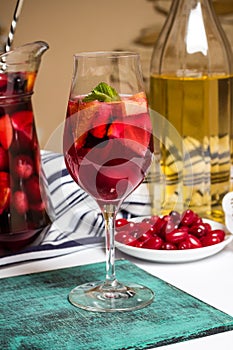 Summer home wine with fruits, sangria cocktail, dogwood berries plate