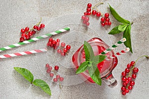 Summer homemade iced drink, cocktail with red currant, ice and mint on rustic table. Copy space and top viewleaf.