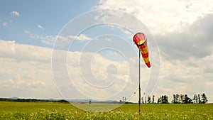 Summer hot day on sport airport with abandoned windsock, wind is blowing