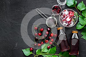 Summer ice berry juice with cherry and cranberry on black table top view copyspace