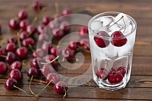Summer iced drink - cherry with ice. On rustic wooden table