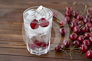 Summer iced drink - cherry with ice. On rustic wooden table