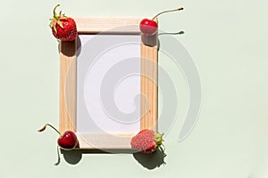 Summer information board,wooden frame on green background with red cherries berries fruits in corner, fresh berry