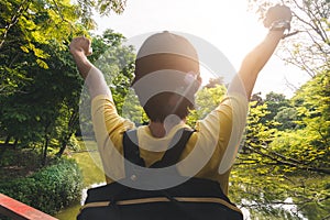 Summer journey vacations concept, Asian man traveler with backpack standing and hand up near tropical forest and looking far away