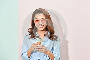 Summer, junk food and people concept - young woman or teenage girl in sunglasses eating ice cream