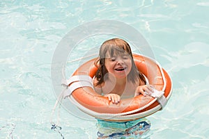 Summer kid vacation. Summertime child weekend. Boy in swiming pool. Toddler at aquapark on inflatable rubber circle.