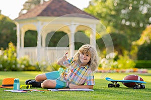 Summer kids leisure. School kid drawing in summer park, painting art. Little painter draw pictures outdoor. Happy child