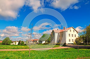 Summer landscape of blue sky, white clouds and green field