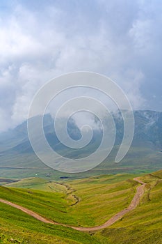 Summer landscape with green hills and cloudy sky. Plateau Assy, Kazakhstan