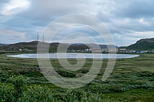 Summer landscape with lake, hills and village