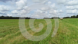 Summer landscape of meadows mown during harvest time. Shot. Haystacks drying under the sun, preparation of animal feed