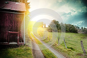 Summer landscape with old barn and country road