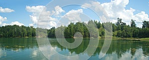 Summer landscape panorama with trees near quiet lake