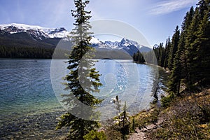 Summer landscape and people kayaking and fishing in Maligne lake, Jasper National Park, Canada