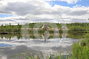 Summer landscape with reflection of Nenets plague in the water in the North of Siberia