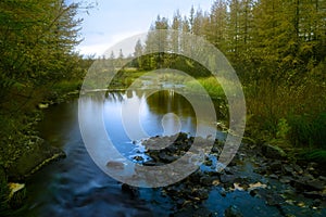 Summer landscape with river cloudy sky forest and sun