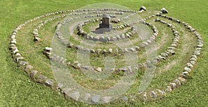 Summer landscape with a stone labyrinth on a green lawn