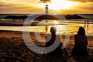 Summer landscape with young caucasian tourist friend watching golden sunset on tropical Khao Lak Beach in Phang Nga in Thailand