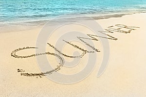 The Summer word written on the beach sand.