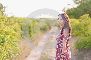 Summer lifestyle portrait of beautiful romantic girl holding bouquet of wild flowers