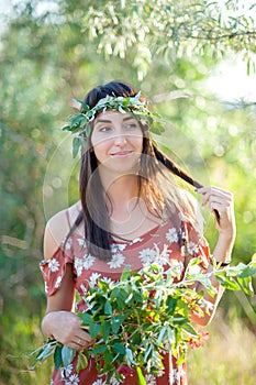 Summer lifestyle portrait of beautiful romantic girl holding bouquet of wild flowers