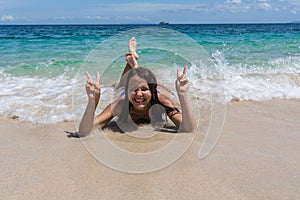 Summer lifestyle portrait of happy pretty young woman with tanned body. Enjoying life and lying in the clear sea