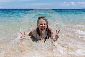 Summer lifestyle portrait of happy pretty young woman with tanned body. Enjoying life and lying in the clear sea