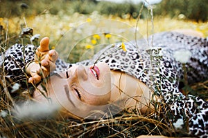 Summer lifestyle portrait middle aged woman lying on the grass outdoor. spends time in nature in summer.