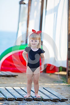 Summer lifestyle portrait of pretty girl swimming posing on the back on the inflatable watermelon in the ocean, wearing stylish