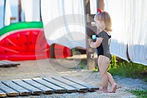 Summer lifestyle portrait of pretty girl swimming posing on the back on the inflatable watermelon in the ocean, wearing stylish