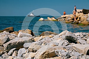 Summer lifestyle and vacation concept. Selective focus on the foreground, blurred island with people and ship in the background