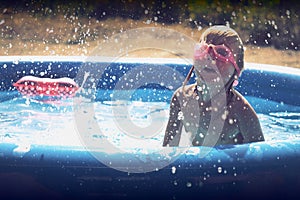 Summer little girl playing in the pool