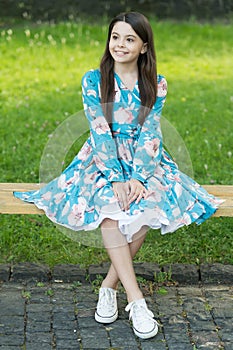 Summer look inspiration. Happy kid sit on park bench. Beauty look of cute girl. Fashion look of little child. Wearing