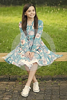 Summer look inspiration. Happy kid sit on park bench. Beauty look of cute girl. Fashion look of little child. Wearing