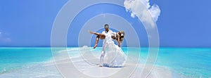 Summer love. Beautiful happy young couple in wedding clothes is standing on a beach in the Maldives. Engagements and wedding on