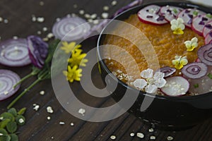 Summer vegetable creme-soup decorated flowers and vegetables