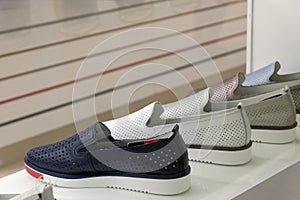 Summer men`s shoes on the store shelf. The concept of sales or seasonal discounts. Copy space