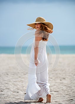 Summer model posing on the beach. Summer dress fashionable woman clothes. Young beautiful hipster woman with straw hat