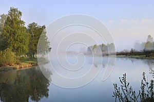 Summer morning on the river with fog, birches on the shore