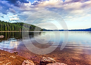 Summer mountain lake theme with cloudy blue sky
