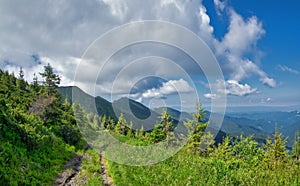 Summer mountain landscape with abandoned dirt road and beautiful cloudy sky