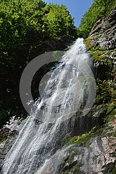 Letná horská krajina so Šútovským vodopádom, jedným z najvyšších vodopádov na Slovensku, počas letnej sezóny.