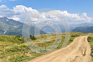 Summer mountain landscape in Svaneti region, Georgia, Asia. Snowcapped mountains in the background. Blue sky with clouds