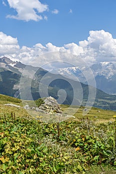 Summer mountain landscape in Svaneti region, Georgia, Asia. Snowcapped mountains in the background. Blue sky with clouds