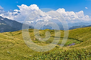 Summer mountain landscape in Svaneti region, Georgia, Asia. Snowcapped mountains in the background. Blue sky with clouds