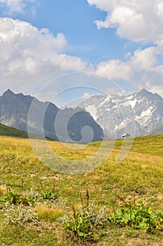 Summer mountain landscape in Svaneti region, Georgia, Asia. Snowcapped mountains in the background. Blue sky with clouds