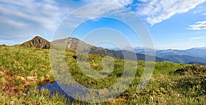 Summer mountain view with puddle (with observatory ruins on Chornogora Ridge, Ukraine