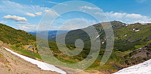 Summer mountain view with snow on mountainside with observatory ruins on Chornogora Ridge, Ukraine